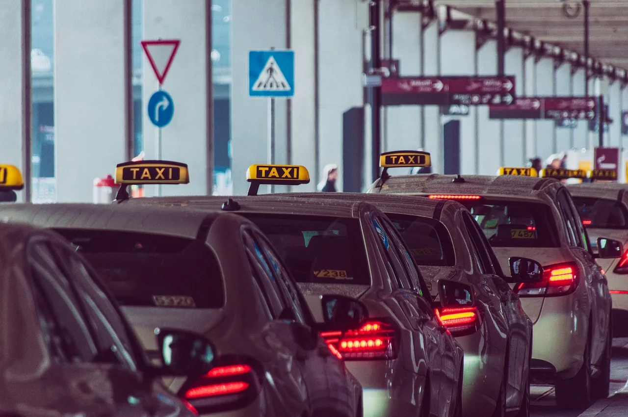 רכבים ומוניות ממתינים מחוץ למסוף הנוסעים בשדה התעופה בדנפסאר בבאלי