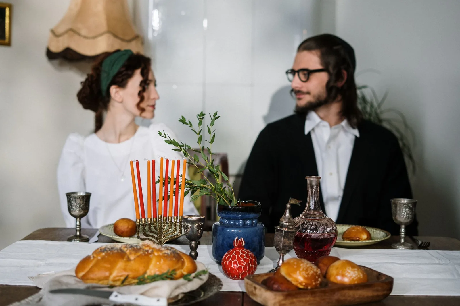 שולחן ארוחת שבת ערוך בבאלי עם נרות, חלות ויין, אווירה חמה ומשפחתית של מטיילים יהודים